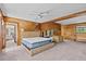 Spacious bedroom with wood paneled walls and ensuite bath with waterfront views at 273 Shore Dr, Palm Harbor, FL 34683