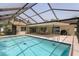 Beautiful pool and patio combination with an enclosure, ceiling fans, and an outdoor grill at 2831 Quail Hollow W Rd, Clearwater, FL 33761