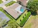 Aerial view of the home featuring a screened-in pool, landscaped yard, and well-maintained roof at 2850 Allapattah Dr, Clearwater, FL 33761