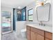 Bright bathroom features an open shower, wood vanity and access to the outdoor pool at 2850 Allapattah Dr, Clearwater, FL 33761