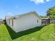 Side view of the house with a well-maintained lawn and a glimpse of the screened-in pool at 2850 Allapattah Dr, Clearwater, FL 33761