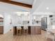 Bright kitchen features island seating, white cabinets, stainless appliances, and wood floors at 2850 Allapattah Dr, Clearwater, FL 33761