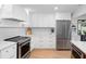 Open kitchen features stainless steel appliances, white cabinetry and marble countertops at 2850 Allapattah Dr, Clearwater, FL 33761
