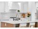 Close-up of the kitchen showcasing white cabinets, stainless appliances, and marble backsplash at 2850 Allapattah Dr, Clearwater, FL 33761