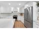 Bright kitchen boasts stainless steel appliances, white cabinetry, marble countertops and wood floors at 2850 Allapattah Dr, Clearwater, FL 33761