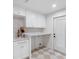 Well lit laundry room features white cabinets, countertop space and a utility sink at 2850 Allapattah Dr, Clearwater, FL 33761