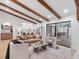 Airy living room with beamed ceilings flows into the kitchen and outdoor living area at 2850 Allapattah Dr, Clearwater, FL 33761