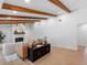 Spacious living room with wooden beam ceilings, stone fireplace and modern console with decor accents at 2850 Allapattah Dr, Clearwater, FL 33761