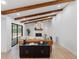 Inviting living room featuring exposed wood beams, a stone fireplace, and modern decor at 2850 Allapattah Dr, Clearwater, FL 33761