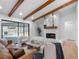 Bright living room features a stone fireplace, wooden beam ceiling, and sliding glass doors to the pool at 2850 Allapattah Dr, Clearwater, FL 33761