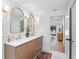 Bright main bathroom featuring a double vanity with gold accents, stylish mirrors and a view to the Main Bedroom at 2850 Allapattah Dr, Clearwater, FL 33761