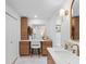 Bright main bathroom with vanity featuring drawers, cabinets, a make up table and decorative lighting and an arched doorway at 2850 Allapattah Dr, Clearwater, FL 33761