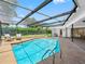 Inviting backyard features a screened pool, outdoor seating area and lush landscaping at 2850 Allapattah Dr, Clearwater, FL 33761