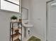 Powder room with pedestal sink, modern fixtures, and decorative plants at 3060 Sutton Woods Dr, Plant City, FL 33566