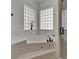 Corner bathtub surrounded by tiled walls and glass block windows for natural light and privacy at 3060 Sutton Woods Dr, Plant City, FL 33566