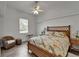 Cozy bedroom featuring a ceiling fan, window with blinds, and tropical-themed bedspread at 3060 Sutton Woods Dr, Plant City, FL 33566