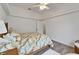 Comfortable bedroom showing a ceiling fan, decorative bedspread and two side tables on wood floors at 3060 Sutton Woods Dr, Plant City, FL 33566