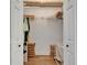 Walk-in closet with hanging clothes and storage boxes on wood floor at 3060 Sutton Woods Dr, Plant City, FL 33566