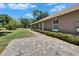 Side view of a house featuring a brick-paved walkway and manicured shrubbery on a sunny day at 3060 Sutton Woods Dr, Plant City, FL 33566
