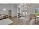 Bright and airy foyer with wood flooring, elegant chandelier and double doors at 3060 Sutton Woods Dr, Plant City, FL 33566