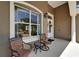 Inviting porch with seating area featuring stylish chairs, lighting and double door at 3060 Sutton Woods Dr, Plant City, FL 33566