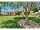 Landscaped front yard featuring mature tree and brick-lined garden bed displaying home address at 3060 Sutton Woods Dr, Plant City, FL 33566