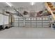Spacious garage featuring epoxy floors, overhead racks, and two garage doors at 3060 Sutton Woods Dr, Plant City, FL 33566