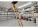Garage with epoxy flooring, ladder to attic, and organized storage at 3060 Sutton Woods Dr, Plant City, FL 33566