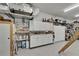 Well-organized garage with epoxy flooring, shelving, and white storage cabinets at 3060 Sutton Woods Dr, Plant City, FL 33566
