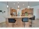 Bright kitchen showcasing an island with bar seating, granite countertops and wooden cabinetry at 3060 Sutton Woods Dr, Plant City, FL 33566