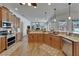 Open-concept kitchen featuring wood cabinets, granite countertops, and stainless steel appliances at 3060 Sutton Woods Dr, Plant City, FL 33566