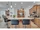 Open kitchen featuring wooden cabinetry, stainless steel appliances, island with bar seating and granite countertops at 3060 Sutton Woods Dr, Plant City, FL 33566