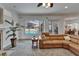Bright living room featuring a leather sofa, ceiling fan, and a view of the outdoor pool at 3060 Sutton Woods Dr, Plant City, FL 33566
