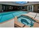 Relaxing pool with a built-in hot tub surrounded by a brick border and a screened-in patio at 3060 Sutton Woods Dr, Plant City, FL 33566