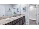 Bathroom featuring double sinks, granite countertops, and a large mirror at 32429 Welling Blade Loop, Wesley Chapel, FL 33545