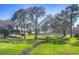 Expansive backyard featuring lush green grass and mature trees, creating a serene and inviting outdoor space at 3292 Covered Bridge E Dr, Dunedin, FL 34698
