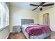Comfortable bedroom featuring a ceiling fan, wood-look floors, and ample natural light at 3292 Covered Bridge E Dr, Dunedin, FL 34698