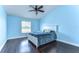 Comfortable bedroom with a ceiling fan, hardwood floors, and natural light at 3292 Covered Bridge E Dr, Dunedin, FL 34698