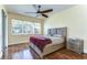 Bright bedroom with a large window, wood flooring, ceiling fan, and a serene atmosphere at 3292 Covered Bridge E Dr, Dunedin, FL 34698