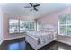 Charming bedroom featuring a ceiling fan, hardwood floors, and windows providing natural light at 3292 Covered Bridge E Dr, Dunedin, FL 34698