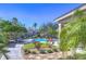 Community pool surrounded by landscaping, lounge chairs, and a security fence at 3292 Covered Bridge E Dr, Dunedin, FL 34698