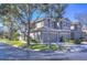 Corner lot townhome featuring a two-car garage, neutral paint, tiled roof and manicured landscaping at 3292 Covered Bridge E Dr, Dunedin, FL 34698
