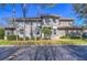 Multi-story home with manicured landscaping, mature trees, and ample parking at 3292 Covered Bridge E Dr, Dunedin, FL 34698