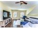 Bright living room with hardwood floors, large windows, modern furniture, and a ceiling fan at 3292 Covered Bridge E Dr, Dunedin, FL 34698