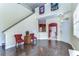 Living room features hardwood floors, stairs, neutral paint, and a kitchen view at 3292 Covered Bridge E Dr, Dunedin, FL 34698