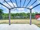 Backyard featuring a pergola, lawn and lush green landscaping beyond a lake at 3301 Elkridge Dr, Holiday, FL 34691