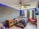 Bedroom with a decorative accent wall, hardwood floors, ceiling fan, and lots of natural light at 3301 Elkridge Dr, Holiday, FL 34691