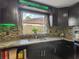 Kitchen featuring granite countertops, updated cabinets, mosaic backsplash, and stainless steel appliances at 3301 Elkridge Dr, Holiday, FL 34691