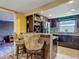 Modern kitchen featuring a breakfast bar with two chairs, wine racks, and stainless steel appliances at 3301 Elkridge Dr, Holiday, FL 34691