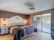 Spacious main bedroom featuring a large bed and sliding glass doors to the bonus room at 3301 Elkridge Dr, Holiday, FL 34691
